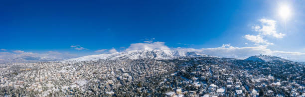 istock Attica Greece. Penteli mountain covered with snow, aerial drone view, blue sky background 1302919464