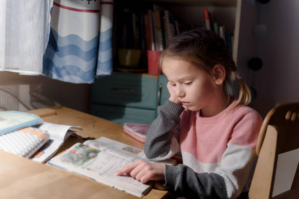 istock Little girl doing homework at home 1302921280
