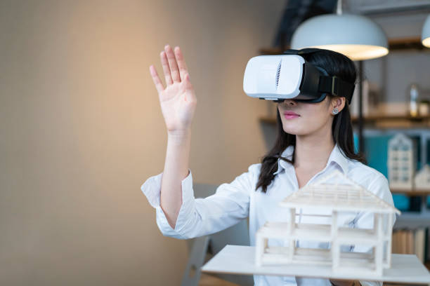 istock Asian woman architect simulate house design with virtual headset goggle at home office 1302923499