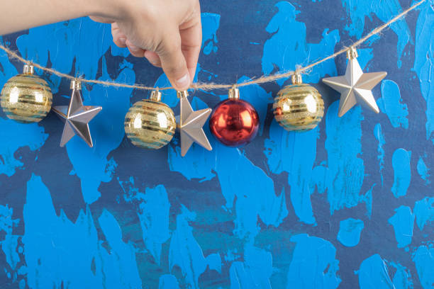 istock Colorful ornaments hanged from the rustic thread on blue textured background 1302924493