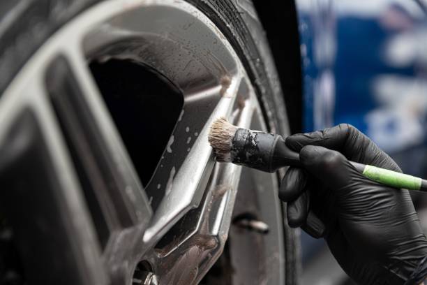 istock Car detailing studio worker cleaning car wheel 1302928174