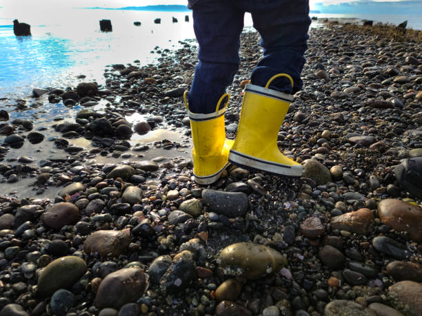 Child in Golashes Wellies Rubber Boots on Beach