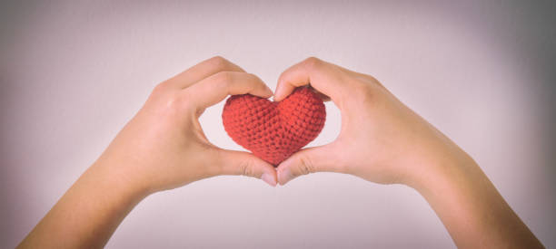 istock Hands gesture heart shape and hold red heart on white isolated background with copy space. Concept for love, help, kindness, donate, heart health, mental healthcare, insurance and csr business plan. 1302932545