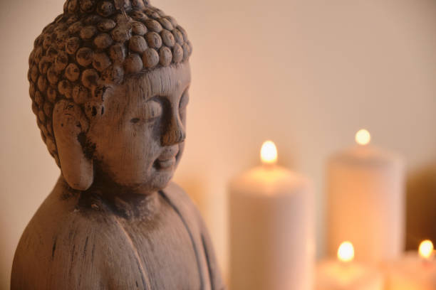 istock buddha figure candles in the background 1302933002