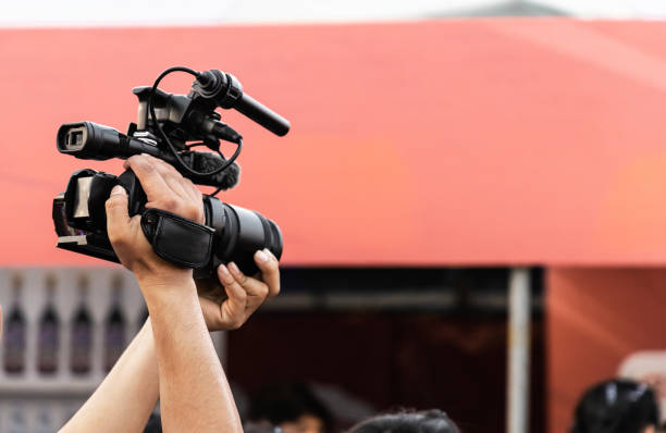 istock Hands of professional video camera operator working with his equipment at night event. 1302933580