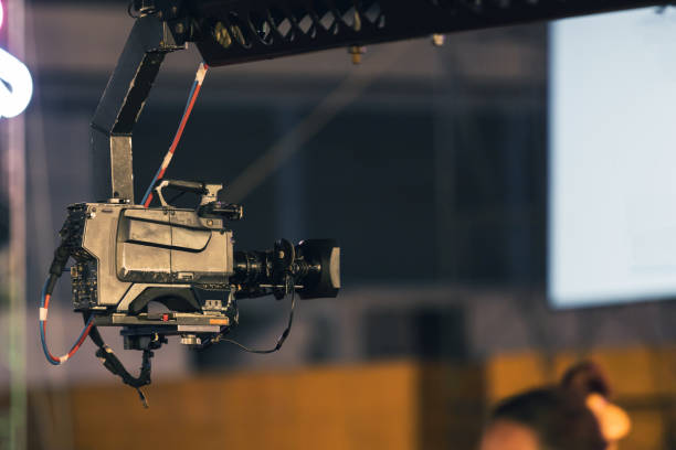 istock Professional digital video camera on crane record live on event broadcasting at night concert outdoors. 1302934147