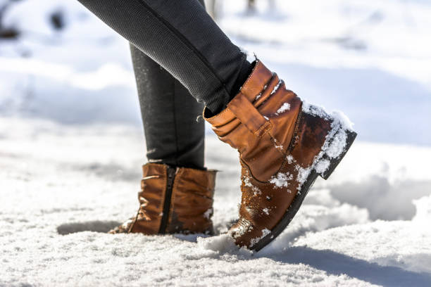 damenstiefel im schnee, braune schuhe für den winter - snow track human foot steps stock-fotos und bilder