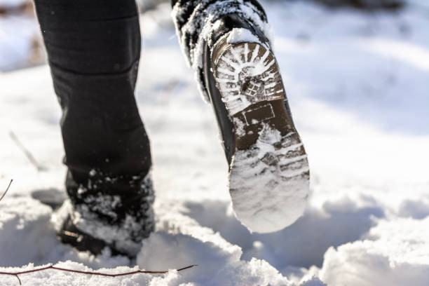 istock Person hiking with boots in snow, shoe sole 1302934620