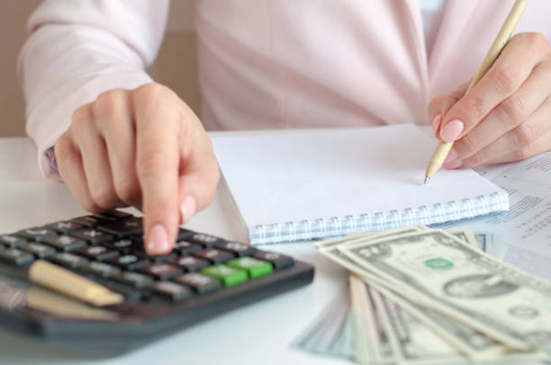 istock close up of woman hands with calculator counting and taking notes to notebook 1302937873