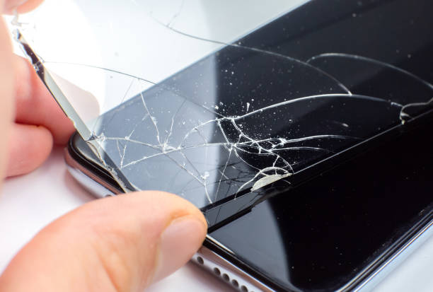 istock Man replacing the broken tempered glass screen protector for smartphone. Close up. 1302939346