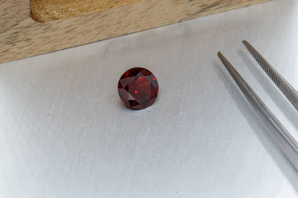 istock macro mineral faceted stone cut Garnet on a gray background 1302940108