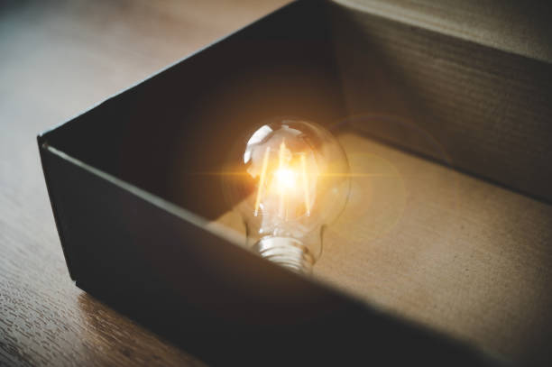istock Light bulb in the black box. Concept of inspiration creative idea thinking and future technology innovation 1302940815