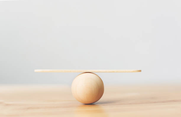 madera ve escala vacía balanceo en esfera de madera sobre mesa de madera - equilibrio fotografías e imágenes de stock