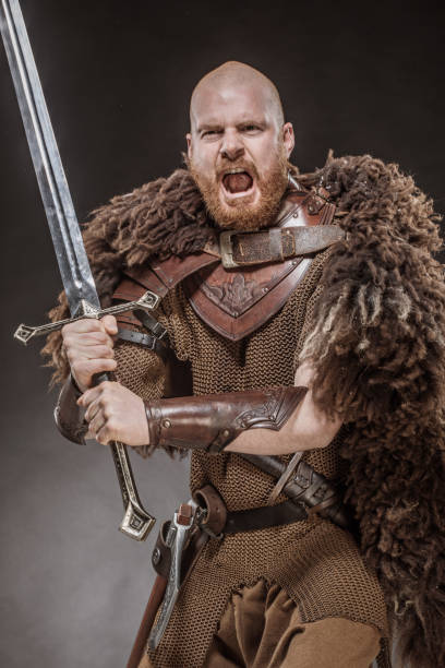 istock Weapon wielding redhead viking warrior in studio shot 1302941467