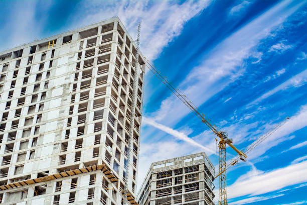 istock Residential high-rise building under construction. Unfinished house on a construction site with cranes. 1302942918