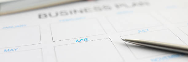istock Silver pen lying over paper monthly plan for june 1302943024