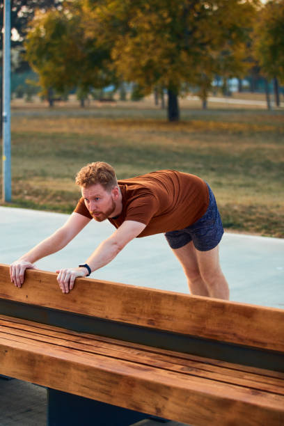 istock Young man making pause after jogging and exercising in urban park. 1302943405
