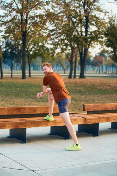 istock Young man making pause after jogging and exercising in urban park. 1302943421