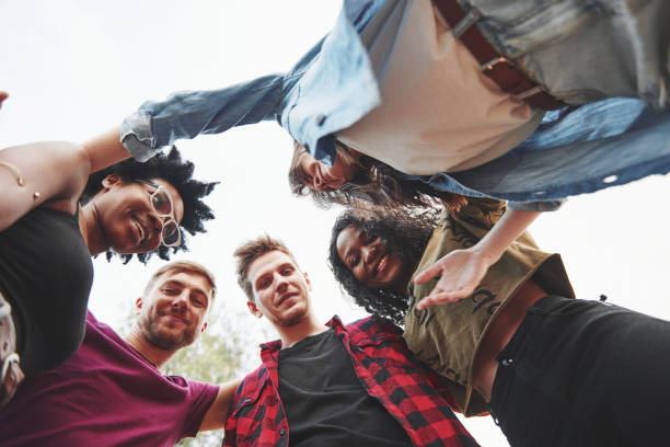 istock Embracing each other. Multi ethnic group of people have party outdoors. View from down 1302945975