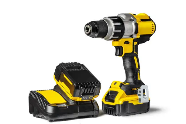 Yellow-black cordless Combi Drill Driver Hammer Drill and extra battery with charger isolated on white background.