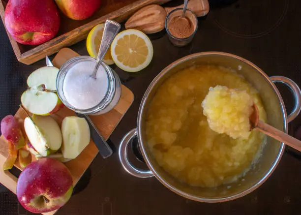 cooking homemade traditional apple sauce on a stove. With fresh ingredients such as apples. sugar fresh lemon juice and cinnamon