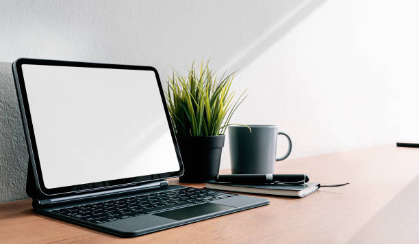 istock Mockup tablet with magic keyboard on wooden table with copy space. 1302949619