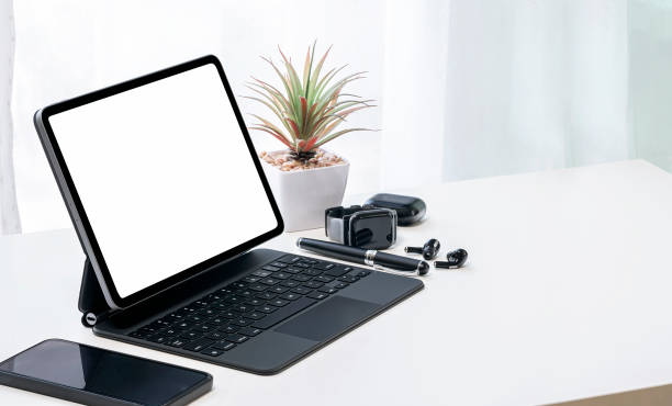 istock Mockup black screen tablet with magic keyboard, smartwatch and earphone on white top table, copy space. 1302949646