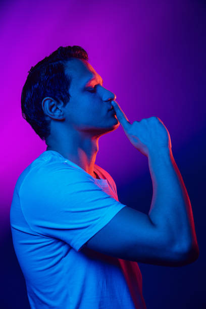 istock Caucasian man's portrait isolated on purple blue studio background in multicolored neon light 1302951210