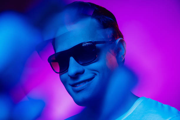 istock Caucasian man's portrait isolated on purple blue studio background in multicolored neon light 1302951216