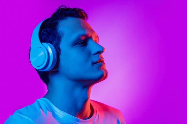 istock Caucasian man's portrait isolated on purple blue studio background in multicolored neon light 1302951227