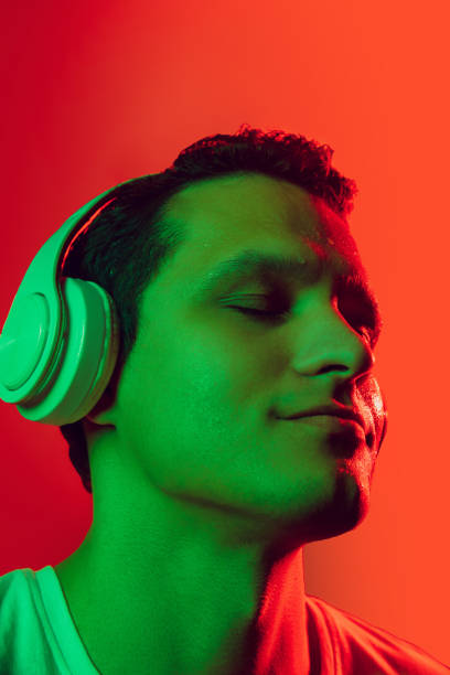 istock Caucasian man's portrait isolated on red studio background in multicolored neon light 1302951243