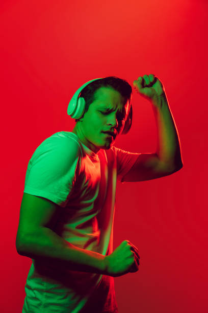 istock Caucasian man's portrait isolated on red studio background in multicolored neon light 1302951244