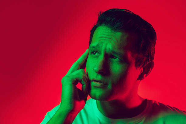 istock Caucasian man's portrait isolated on red studio background in multicolored neon light 1302951253
