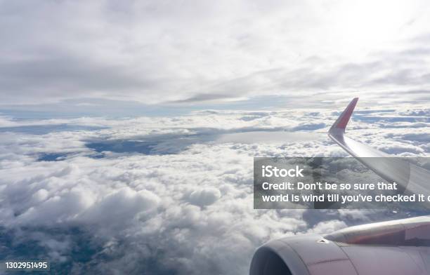 Sky Scape View From Clear Glass Window Seat To The Aircraft Wing Of The Air Plane Traveling On White Fluffy Clouds And Vivid Blue Sky Stock Photo - Download Image Now