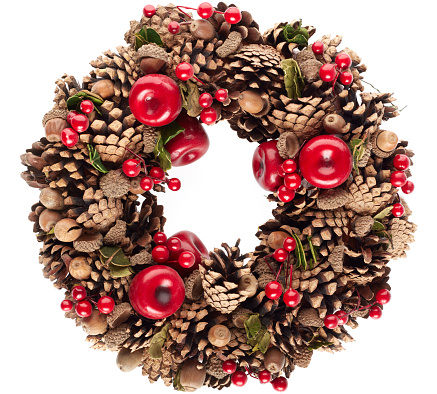 Christmas wreath with pine cones, red berries and acorns isolated on white background