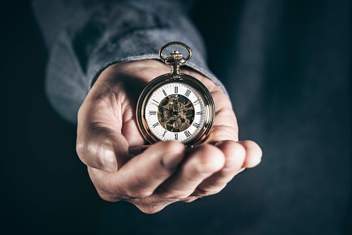 Man holding pocket watch concept for time, deadline and urgency