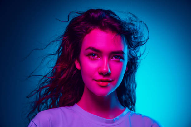 istock Caucasian woman's portrait isolated on blue studio background in multicolored neon light 1302953766