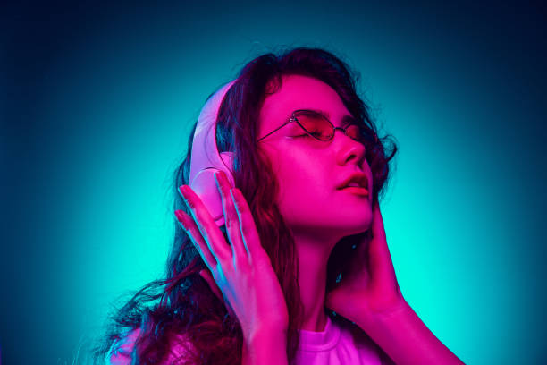istock Caucasian woman's portrait isolated on blue studio background in multicolored neon light 1302953773