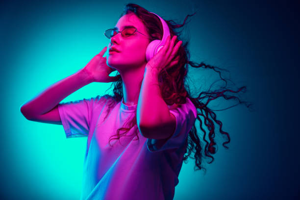 istock Caucasian woman's portrait isolated on blue studio background in multicolored neon light 1302953776