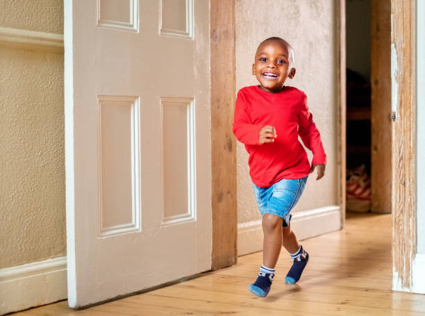 istock Cute smiling boy running down the passage in the home 1302954120