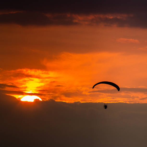 istock Yellow and red sun light ray in the evening dark paraglider 1302955499
