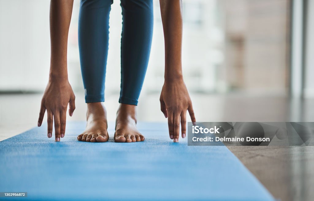 Good health is well within your reach Shot of an unrecognisable woman practicing a yoga routine at home Yoga Stock Photo