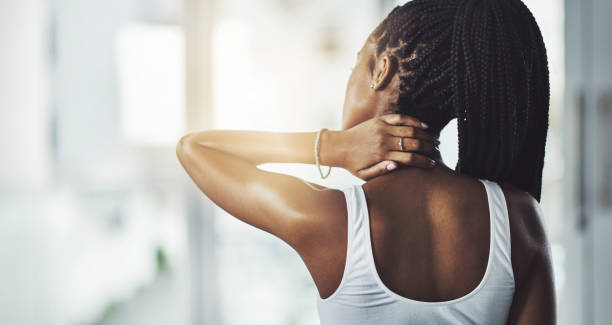 Give your neck a break with a standing workout Rearview shot of a young woman experiencing neck pain while working out inflammation photos stock pictures, royalty-free photos & images