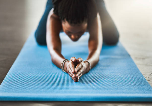 Shot of a young woman practicing a yoga routine at home
