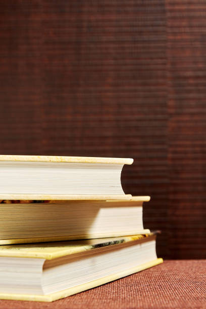 istock Messy stack of books on the brown bookshelf in the library. Bookstore backgrounds 1302956959
