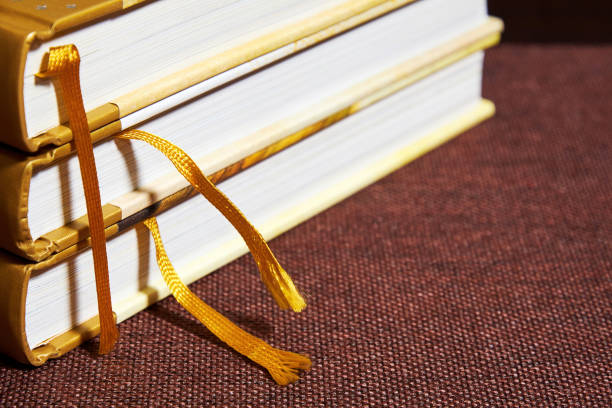 istock Stack of vintage hardcovered books with bookmarks on a bookshelf. Bookshop background texture 1302956968