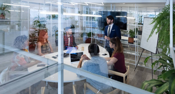 istock Presentation in business team meeting, seen from outside through windows 1302957883