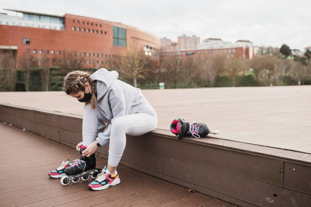 istock Young woman putting on roller skates 1302958126