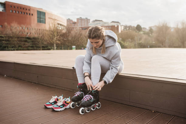 istock Young woman putting on roller skates 1302958526