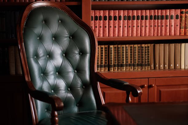 istock Dark solid interior of old library with books on the wooden shelves. 1302960098